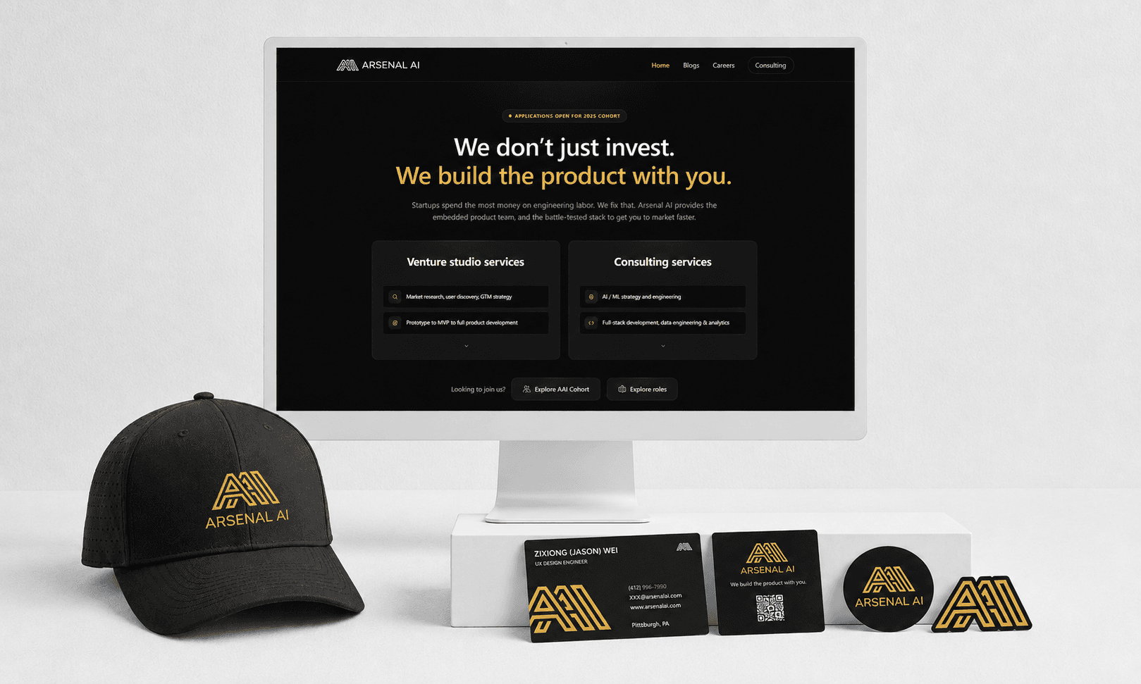 Arsenal AI brand mockup: the public site on a monitor beside a branded cap, business cards, and stickers